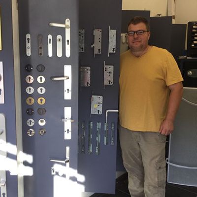Slotenmaker Rob bij de slotenwand in zijn winkel in Wilrijk, ook uw slotenmaker in Deurne